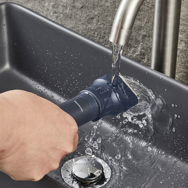 Hand rinsing Multishape under running water in a sink