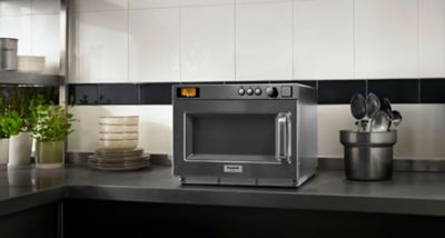 Die kompakte Hochleistungs-Inverter-Mikrowelle NE-1815 von Panasonic, aufgestellt auf einer modernen Küchenarbeitsplatte. 