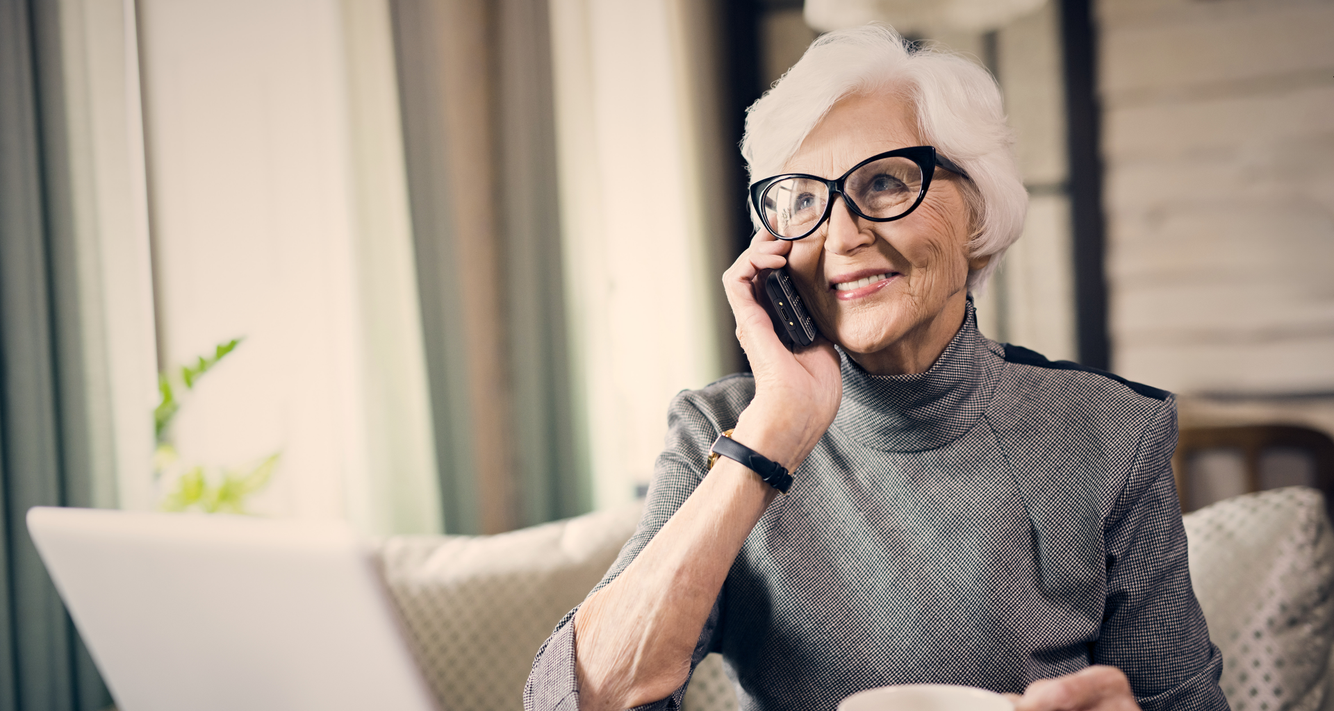 An elderly woman sits indoors and talks on a TU260 mobile phone.