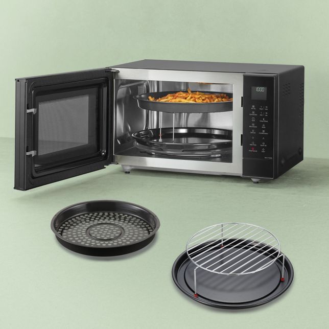 Este prezentat un cuptor cu microunde mixt Panasonic din seria Slim Line, cu ușa deschisă și mâncare în interior, alături de accesoriile incluse expuse în față: coșul pentru friteuză, grătarul și tava emailată.