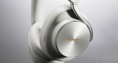 Close-up of the greige Technics EAH-A1000 housing and gold Technics logo.